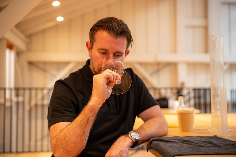 Smelling a glass of white wine during a blending session
